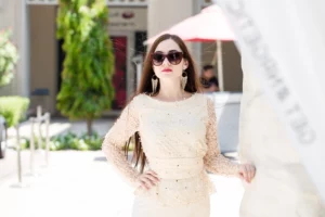 A woman with stylish sunglasses and long earrings, exuding a trendy and summer sophisticated vibe.